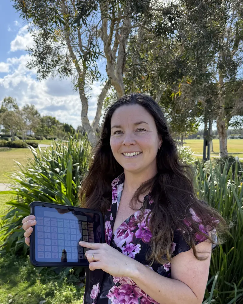 Leia Wilton, speech pathologist, holding a tablet with a communication app